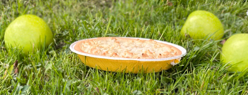 Apple Pie on grass with three green apples